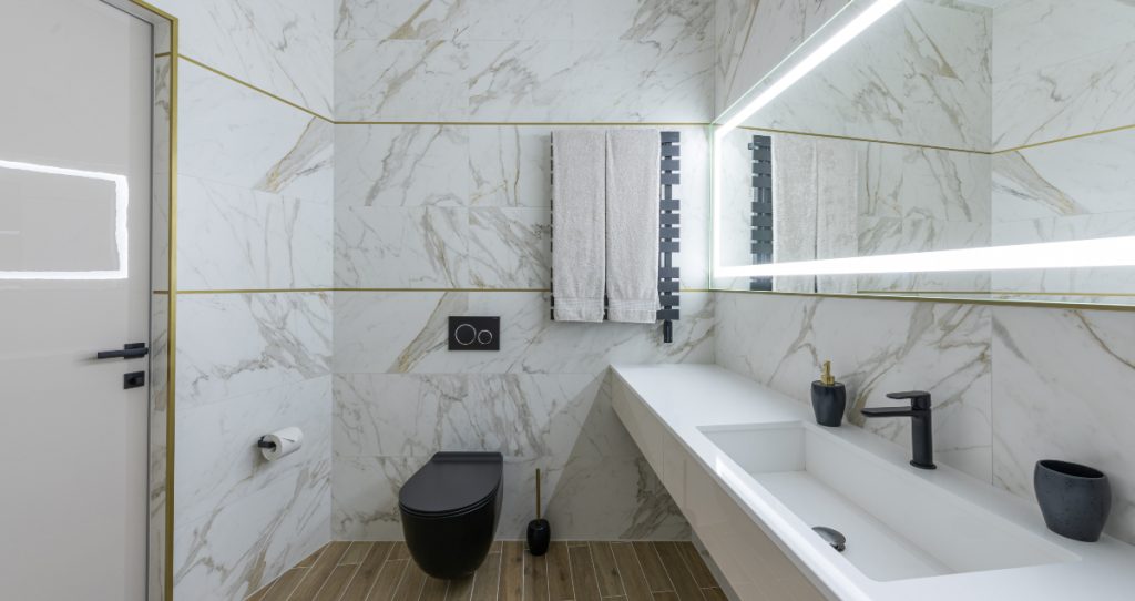 Ideas modernas para renovar baños con revestimientos de mármol y sanitarios en blanco y negro.