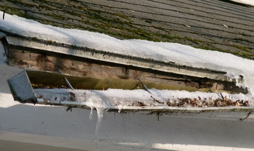 Foto de un techo con canaletas rotas con agua congelada Canalones rotos con agua congelada