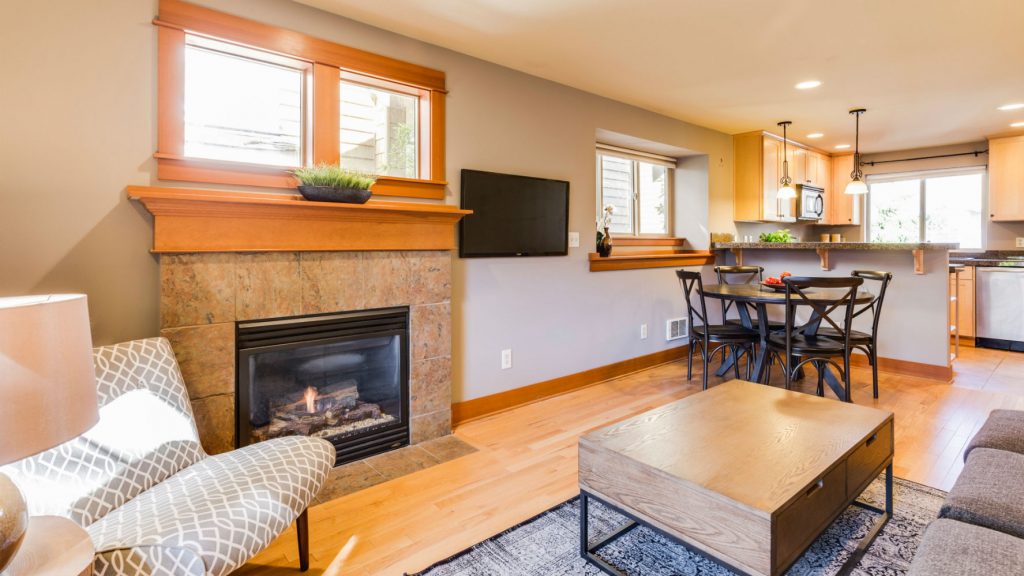 Una sala de estar con cocina de planta abierta amueblada en un estilo clásico con colores cálidos.