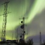 Aurora boreal sobre torres de comunicación