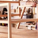 Diseñador de muebles lijando el marco de una silla de madera
