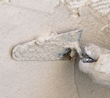 Paleta que esparce la cal en la pared Cal que se esparce en la pared